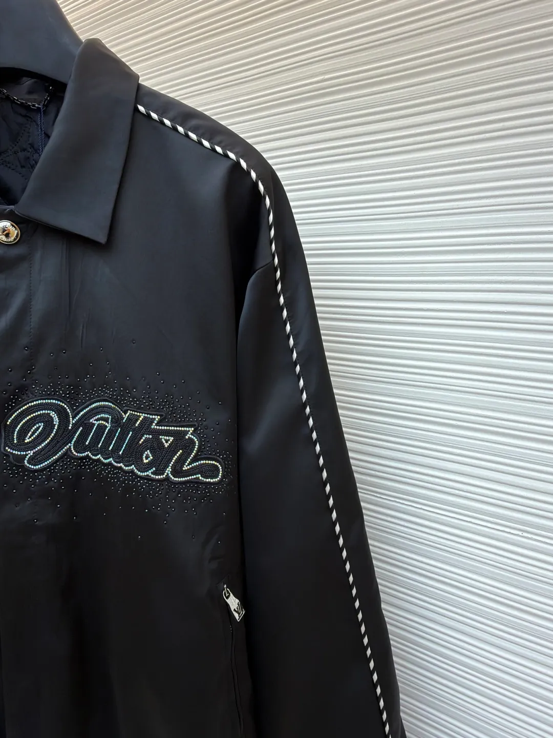 LOUIS VUITTON chest embroidered rhinestone jacket ●Original version: Purchased and developed at 22889 ●Item number: 1681600-B70 ●Material: 100% cotton ●Technology: rhinestone production ●Color: black ●Version: Fitted version ●Weight: about 740 grams ●Size: 46-48-50-52 ●Description: This Louis Vuitton jacket is made of high-quality black satin material, with a delicate texture and rich luster. The craftsmanship incorporates a variety of advanced production technologies: the eye-catching brand logo on the chest is combined with three-dimensional embroidery and hot-drilling technology. The stitching is precise and layered, highlighting the brand's unique recognition; the black and white braided belt decoration on the shoulders and sides not only increases the visual hierarchy, but also enhances the overall sense of fashion and sophistication. The neckline and cuffs are neatly cut and have smooth lines, showing a simple yet high-end style. The zipper and metal buckle have exquisite details and outstanding texture. Manual tile measurement, the error of 1-3CM is within the normal range, which is also the uniqueness of manual craftsmanship. Whether it is worn for daily wear or paired with a jacket, it can easily show fashionable taste and luxurious temperament. The overall wiring is straight and delicate, the fabric is comfortable and soft, and the color is consistent without color difference. It can be matched with the same style to create a fashionable look and control various occasions. Customized accessories, complete with three standards, same style for men and women!